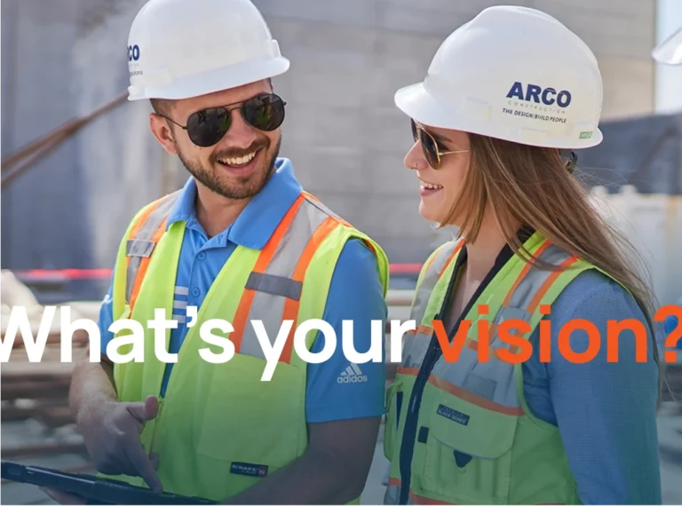 ARCO Construction employees walking on a site, smiling and talking.