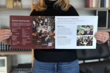 An Atomicdust team member holds the De Smet annual report