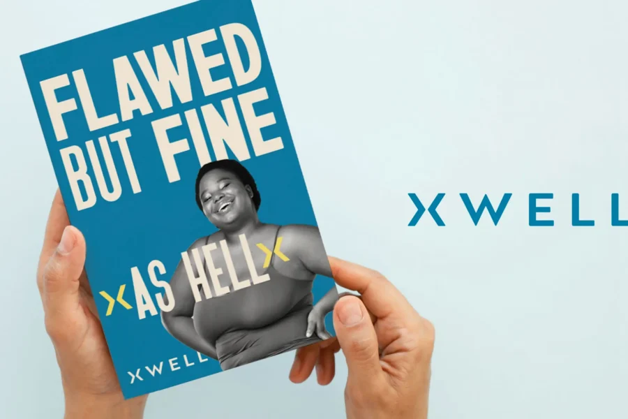 Hands holding an XWELL branded printout that says "Flawed but fine as hell"