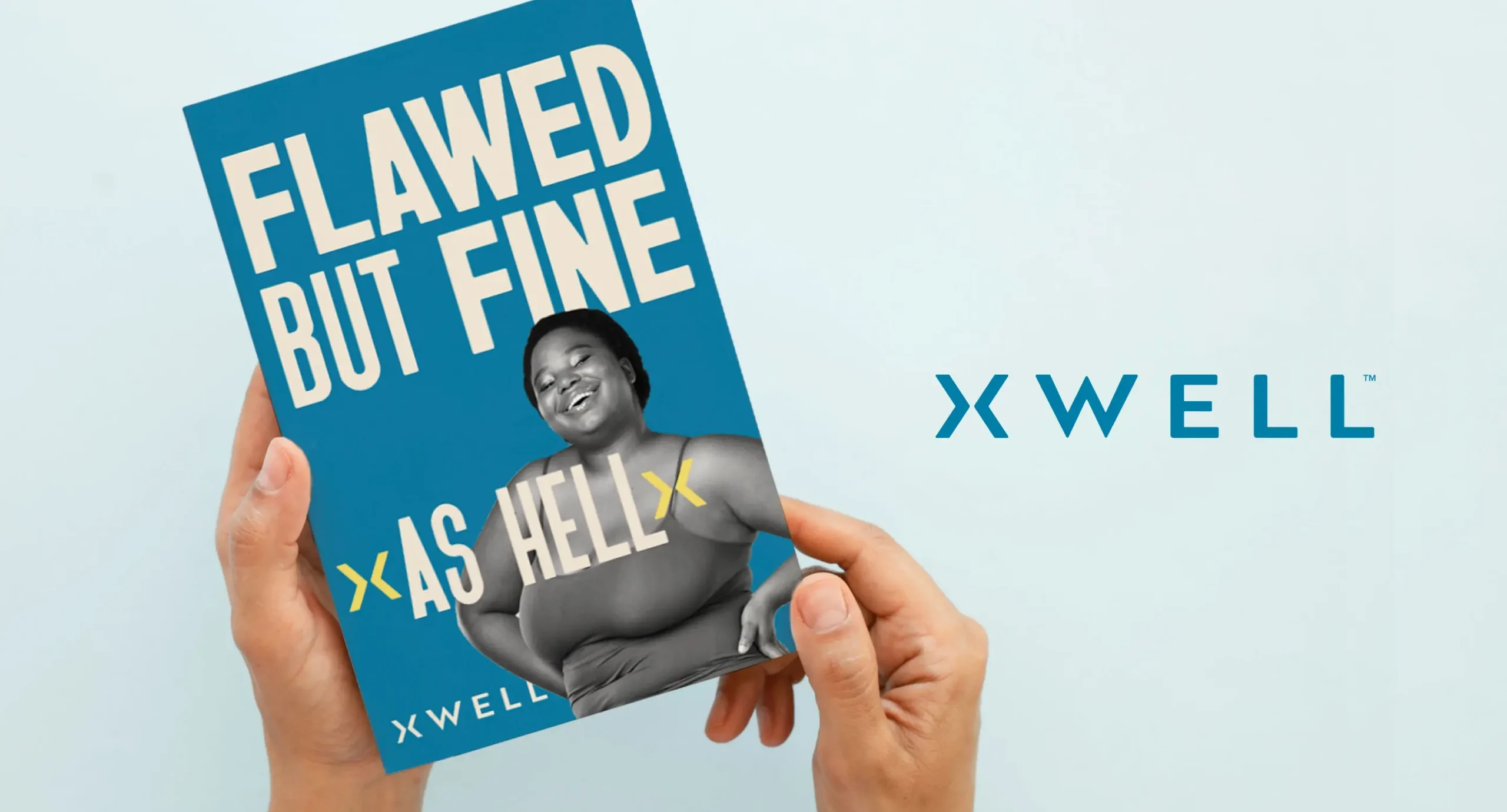 Hands holding an XWELL branded printout that says "Flawed but fine as hell"