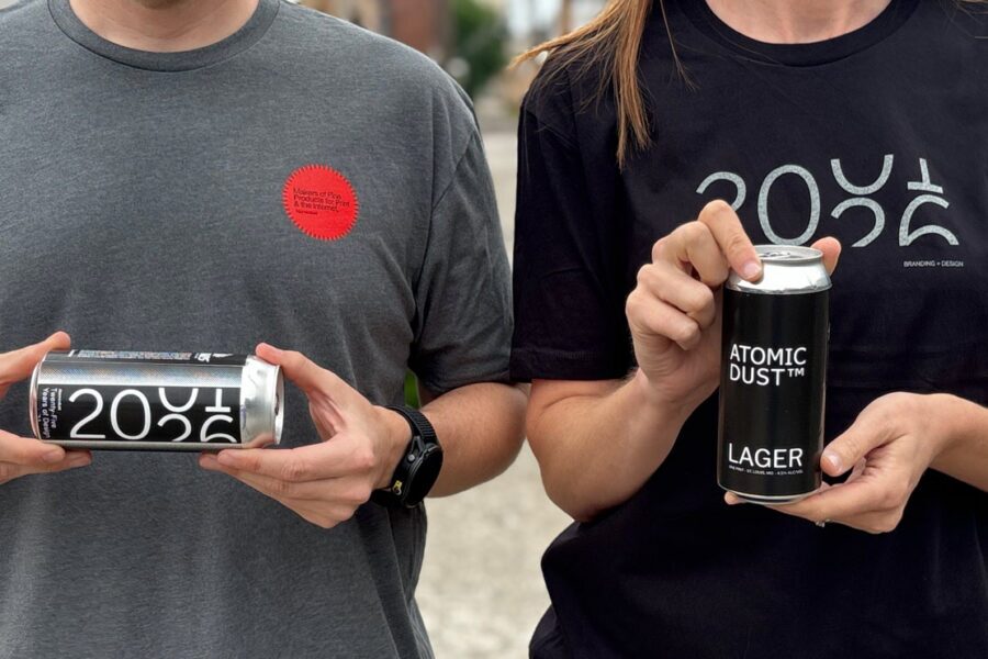 Atomicdust team members wearing 25th anniversary t-shirts and holding custom-labeled beers a client surprised us with for our party