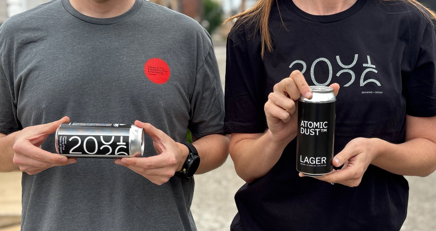 Atomicdust team members wearing 25th anniversary t-shirts and holding custom-labeled beers a client surprised us with for our party