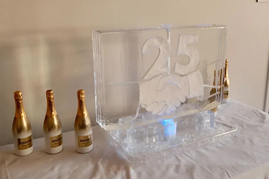 An ice sculpture shot luge of two shaking hands at the Atomicdust 25th anniversary party